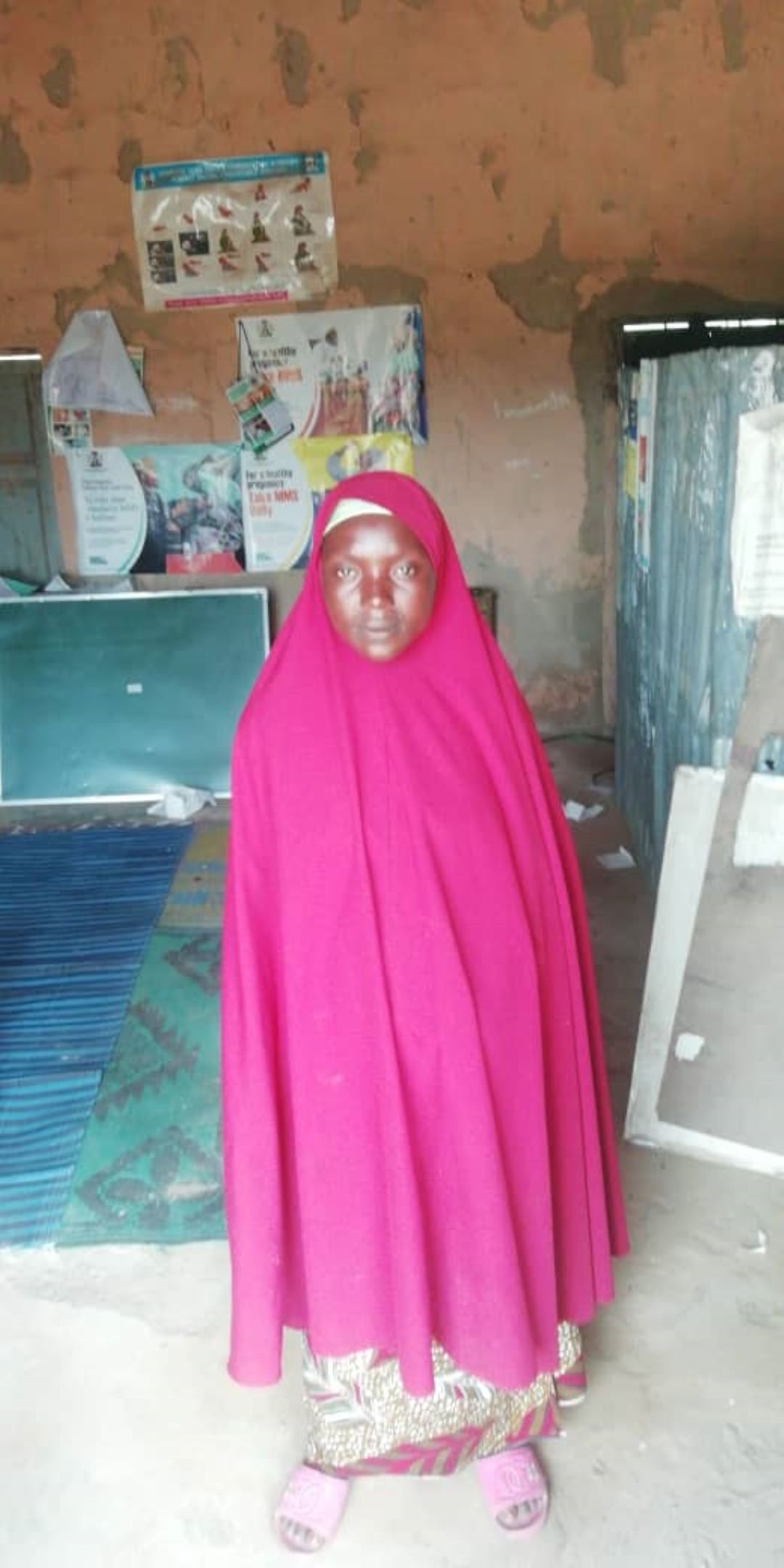 Basira Jibrin, a mother waits for treatment in Batsari’s improvised clinic. (Credit: Husaini Kafi/AHR,2025)