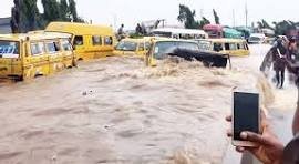 Flooded street in Lagos with cars submerged after heavy rainfall.