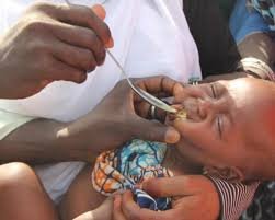 Health worker giving malaria preventive medicine to Nigerian child