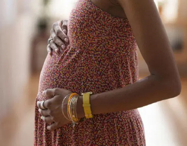 Teenage mother holding her baby at a community health centre in Nigeria