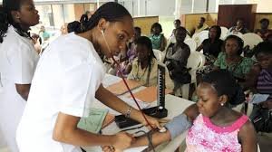 A Nigerian nurse attends to a patient in a rural clinic, symbolising the country’s fragile healthcare system.