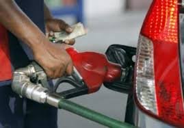 Fuel pump attendant dispensing petrol at a filling station in Nigeria