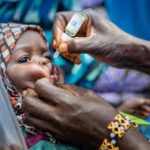 Health workers administering polio vaccine to children in Kano community