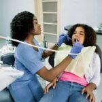 A Nigerian dentist attends to a young patient at a public hospital, , highlighting the growing oral health crisis and limited access to preventive care in Nigeria.