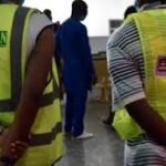 Nigerian airport infrastructure with aviation workers discussing TSA policy