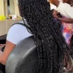Women braiding hair in a Nigerian salon highlighting widespread use of extensions