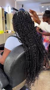 Women braiding hair in a Nigerian salon highlighting widespread use of extensions