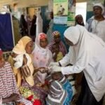 Nigerian health workers attending to patients in a primary healthcare centre