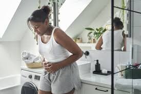 Young Nigerian woman experiencing stomach pain linked to H. pylori infection and poor sanitation
