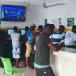 Young Nigerians engaging in sports betting at a betting shop in Abuja