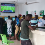 Young Nigerians engaging in sports betting at a betting shop in Abuja