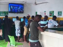 Young Nigerians engaging in sports betting at a betting shop in Abuja