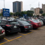 Vehicles parked along a busy Lagos street under traffic management measures