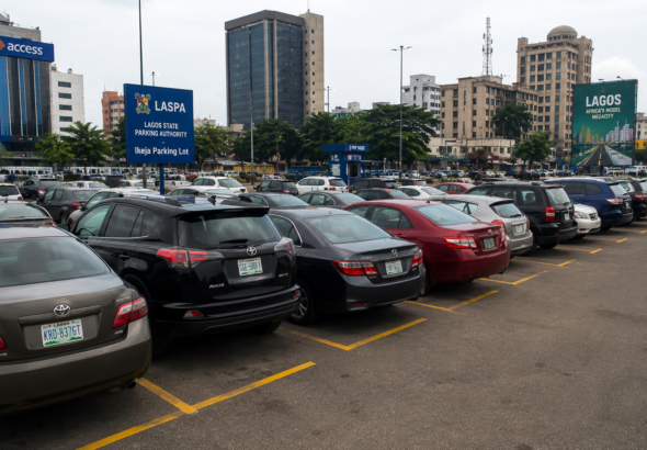 Vehicles parked along a busy Lagos street under traffic management measures