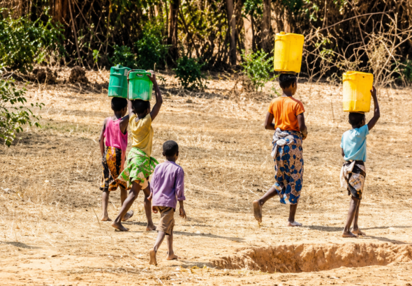 Children carrying jerrycans while searching for water before school in Kano.