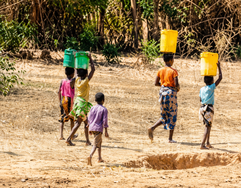Children carrying jerrycans while searching for water before school in Kano.