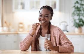 Young Nigerian woman holding medication in a private setting