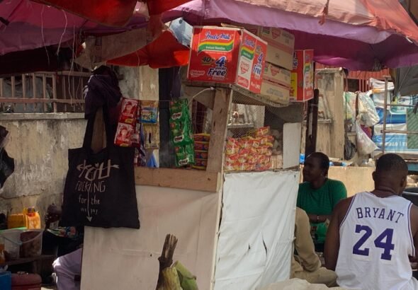 Photo Caption:Madam Rose attends to customers at her roadside food stall in Utako Market, Abuja, where quick processed meals are increasingly replacing traditional home-cooked dishes. (Photo credit: Otamere Gladness/AHR)