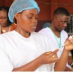 Healthcare workers administering vaccines to children in Africa.