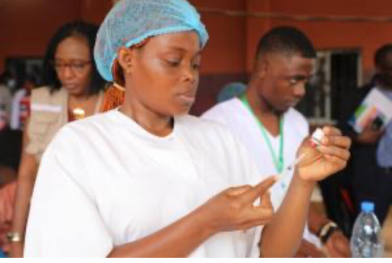 Healthcare workers administering vaccines to children in Africa.