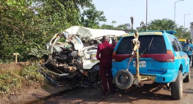 Emergency responders attend to a container truck that overturned onto a passenger bus on a Lagos bridge.